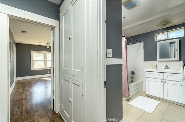 full bath with visible vents, a ceiling fan, shower / tub combo, baseboards, and vanity