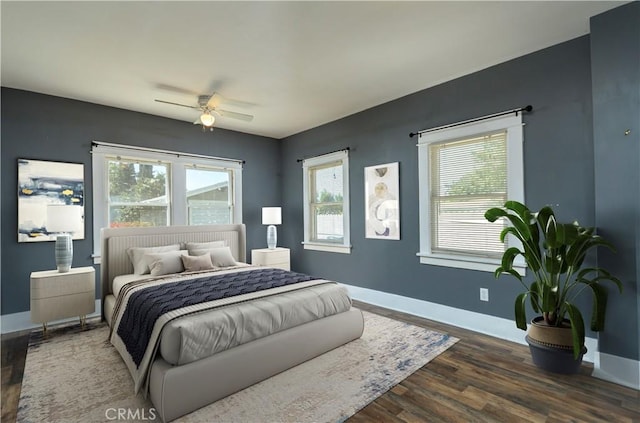 bedroom featuring baseboards, wood finished floors, and a ceiling fan