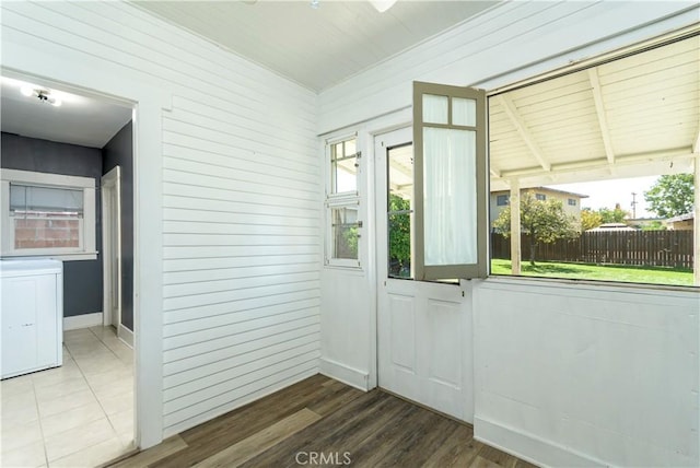 doorway with wood finished floors, baseboards, and a wealth of natural light