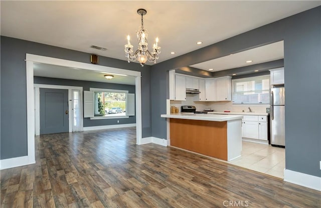 kitchen with visible vents, a notable chandelier, open floor plan, stainless steel appliances, and light countertops