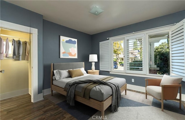 bedroom with baseboards and wood finished floors