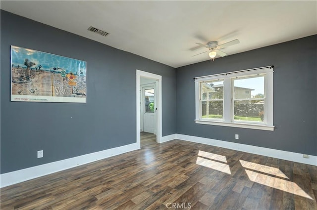 spare room with visible vents, baseboards, ceiling fan, and wood finished floors