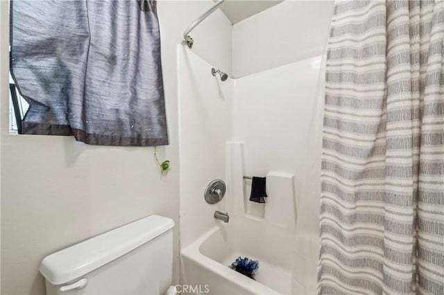 full bathroom featuring shower / bath combo with shower curtain and toilet