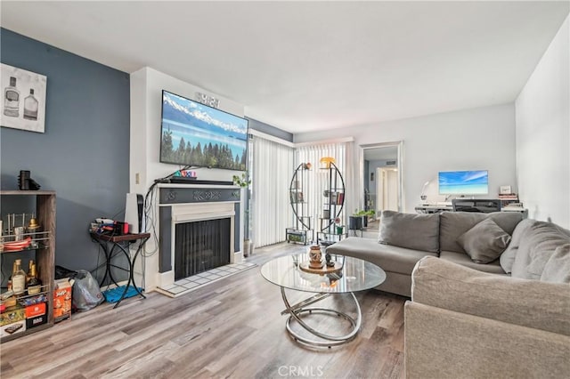 living area with a fireplace with flush hearth and wood finished floors