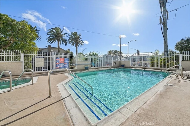 community pool featuring a patio area and fence