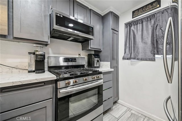 kitchen with stainless steel appliances, baseboards, and gray cabinetry