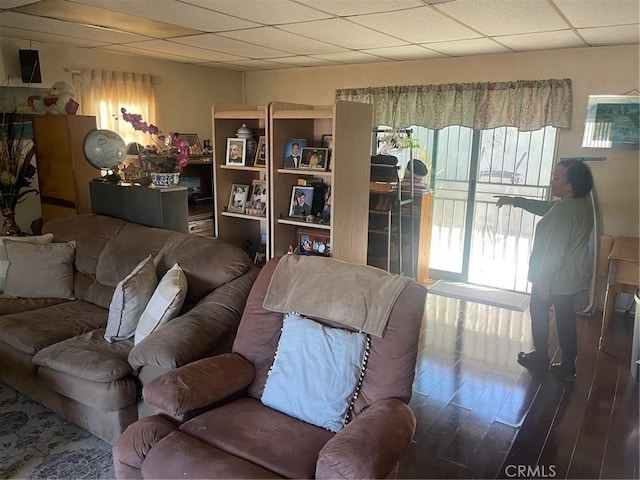 living room with a paneled ceiling, a healthy amount of sunlight, and wood finished floors