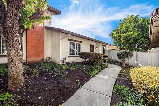 view of front of house with fence and stucco siding