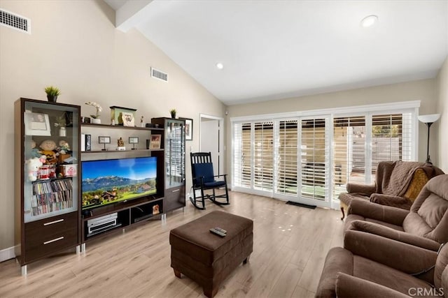 living area with beam ceiling, high vaulted ceiling, visible vents, and light wood-type flooring