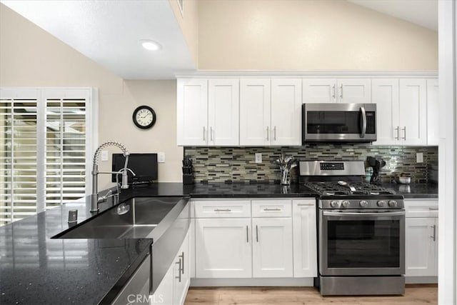 kitchen featuring white cabinetry, lofted ceiling, and stainless steel appliances