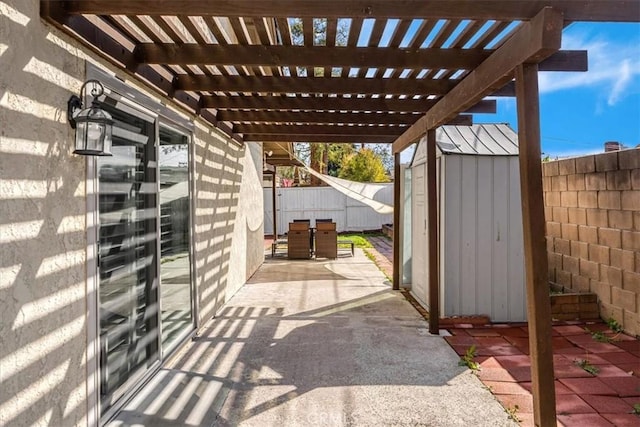 view of patio featuring outdoor dining space, a storage shed, a fenced backyard, and an outdoor structure