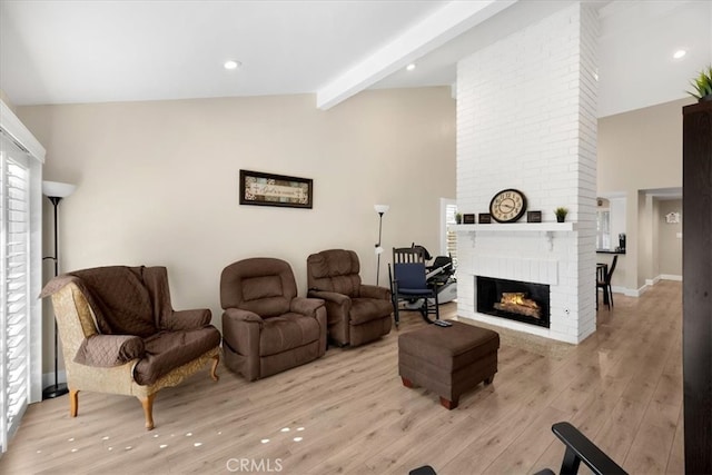 living room featuring beamed ceiling, high vaulted ceiling, light wood-style flooring, recessed lighting, and a brick fireplace