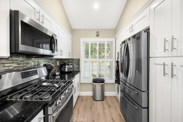 kitchen with light wood-style flooring, backsplash, white cabinetry, appliances with stainless steel finishes, and baseboards