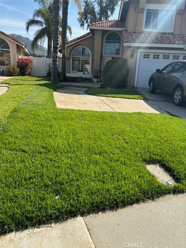 10402 Via Pajaro, Moreno Valley, CA 92557 - exterior space with a tile roof, concrete driveway, stucco siding, fence, and a front lawn