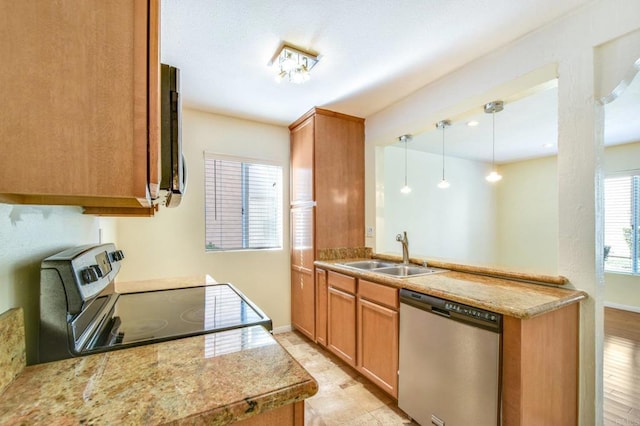 kitchen with a peninsula, a sink, stainless steel appliances, decorative light fixtures, and brown cabinets