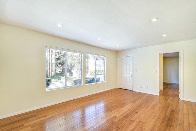 empty room with recessed lighting, baseboards, and light wood-style floors