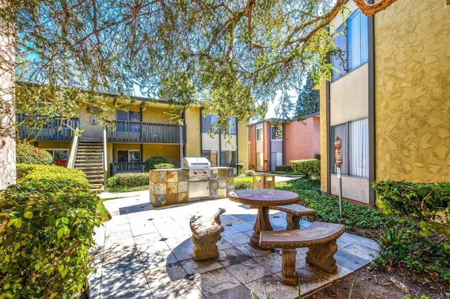 view of patio / terrace featuring stairway, area for grilling, and an outdoor kitchen