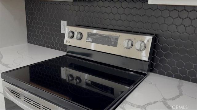 room details with stainless steel range with electric cooktop and light stone countertops