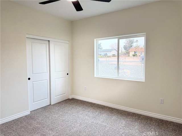 unfurnished bedroom featuring a ceiling fan, baseboards, a closet, and carpet floors