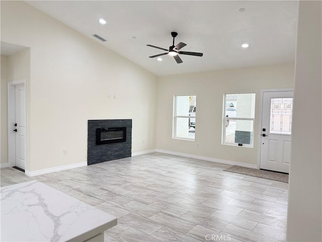 unfurnished living room with a ceiling fan, visible vents, recessed lighting, vaulted ceiling, and a glass covered fireplace