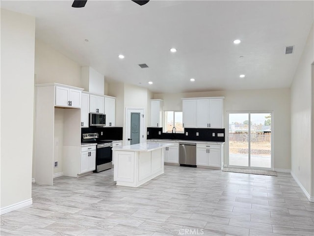 kitchen featuring visible vents, light countertops, decorative backsplash, appliances with stainless steel finishes, and a ceiling fan