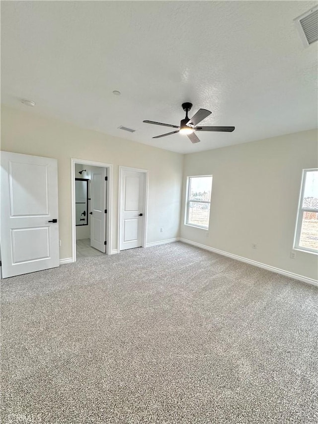 unfurnished bedroom featuring baseboards, visible vents, and carpet floors