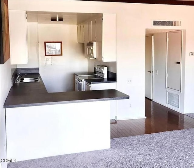 5460 White Oak Ave Unit C339, Los Angeles, CA 91316 - kitchen with electric stove, a sink, dark countertops, and dark wood-style flooring