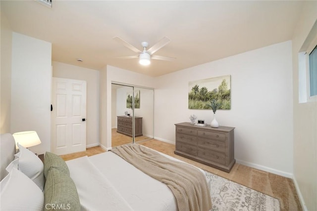 carpeted bedroom with a closet, baseboards, and ceiling fan