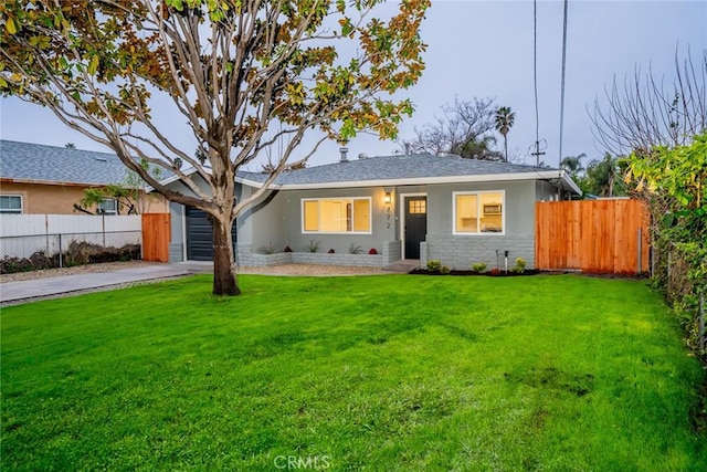 ranch-style home featuring a front yard, fence, an attached garage, stucco siding, and concrete driveway