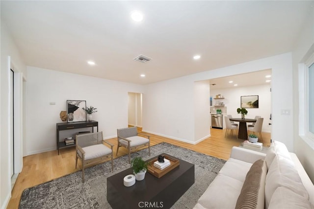 living room featuring visible vents, recessed lighting, baseboards, and light wood-style floors