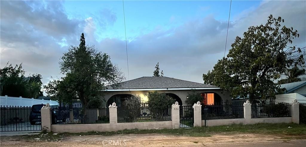 view of front of property featuring a fenced front yard, stucco siding, and a gate