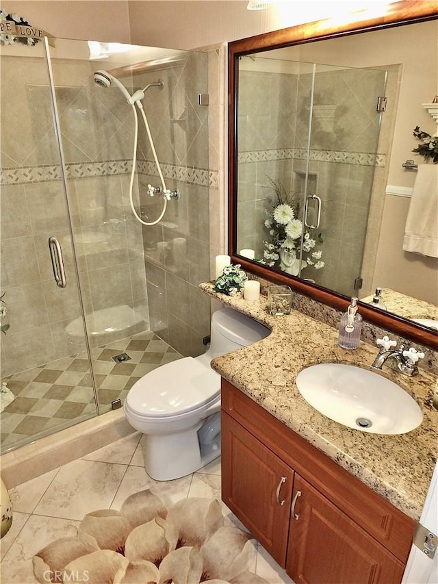 bathroom with a shower stall, toilet, and vanity