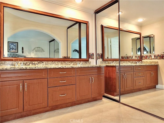 bathroom with tile patterned floors, ornamental molding, a sink, recessed lighting, and double vanity