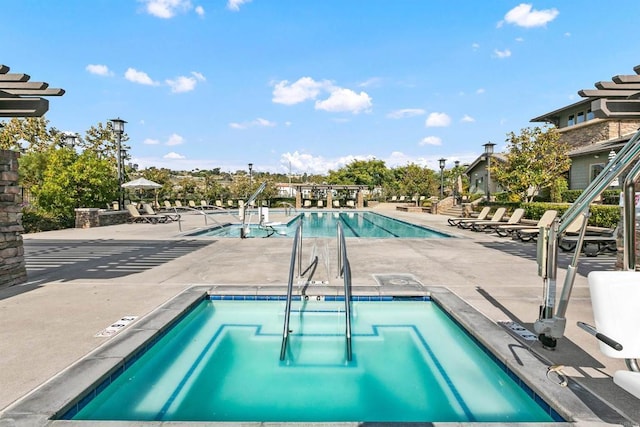 community pool featuring a patio area and a hot tub