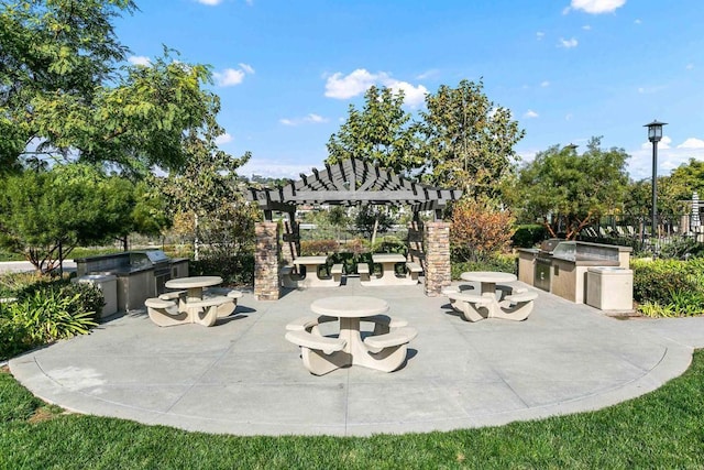 view of patio with area for grilling and a pergola