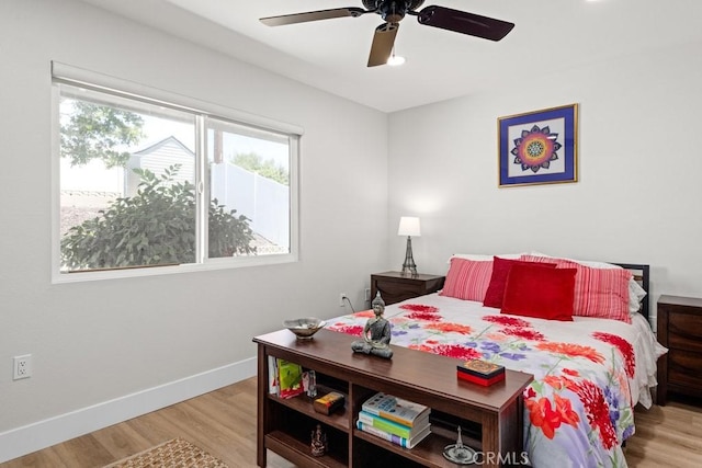 bedroom featuring baseboards, ceiling fan, and light wood finished floors