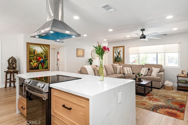 kitchen featuring visible vents, light wood-type flooring, a ceiling fan, electric stove, and island exhaust hood