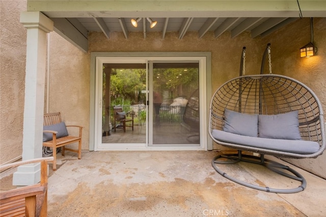 property entrance with a patio area and stucco siding