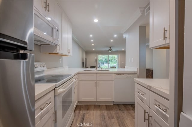 kitchen with white appliances, light wood-style flooring, crown molding, and ceiling fan