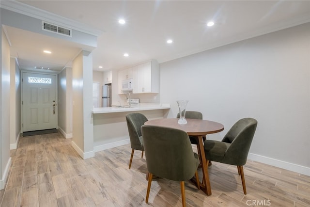 dining space with visible vents, crown molding, baseboards, light wood-type flooring, and recessed lighting