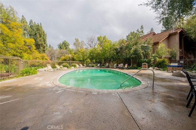 pool with fence and a patio area