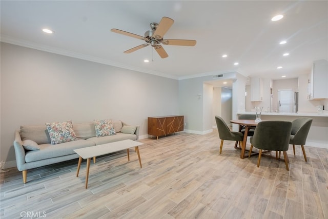 living area featuring recessed lighting, crown molding, light wood-type flooring, and baseboards