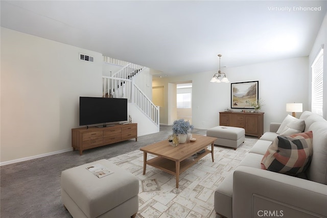 living area featuring stairway, a healthy amount of sunlight, light colored carpet, and baseboards