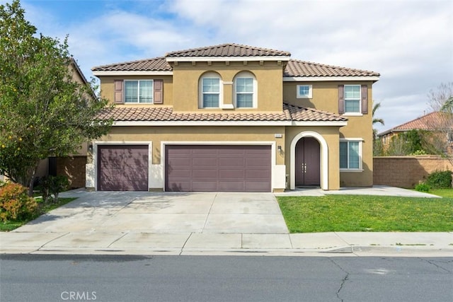 mediterranean / spanish-style home with a tiled roof, a garage, driveway, and stucco siding