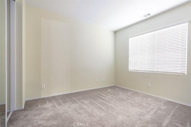 carpeted spare room with visible vents