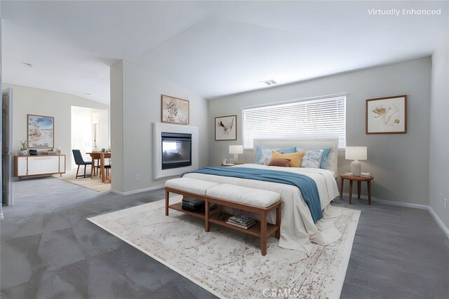 bedroom featuring a glass covered fireplace, vaulted ceiling, baseboards, and visible vents