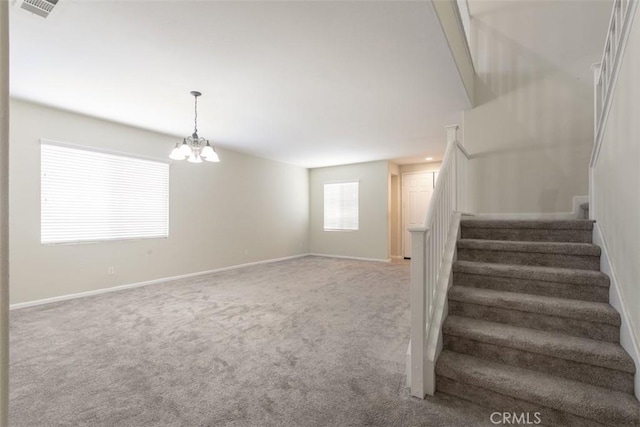 stairs featuring carpet flooring, visible vents, baseboards, and an inviting chandelier