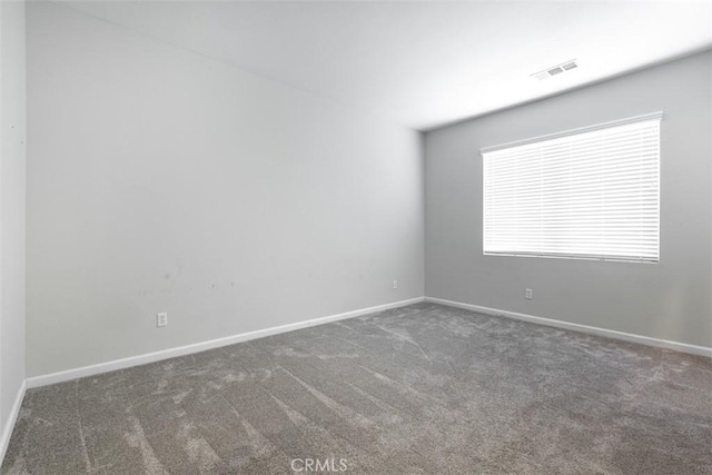 carpeted spare room with baseboards and visible vents