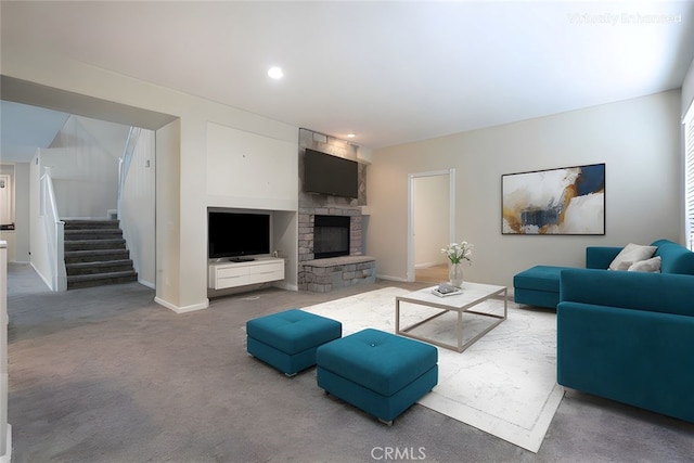 carpeted living room with stairs, a stone fireplace, recessed lighting, and baseboards