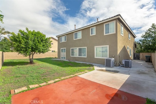 rear view of property with a fenced backyard, stucco siding, a patio, and central AC